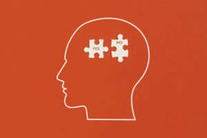 Human head with puzzle on red background.