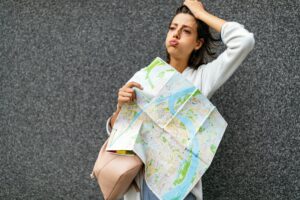 Confused tourist woman on the street looking at a map