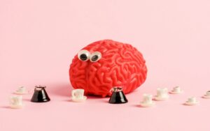 Funny human brain model with googly eyes and a lot of coffee cups.